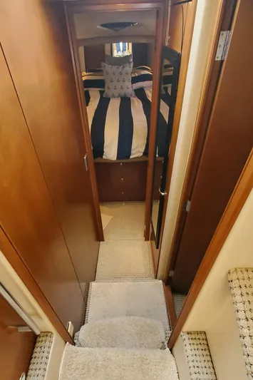 Chelarious Yacht Photos Pics Interior view of 2005 Meridian 411 Sedan, featuring a cozy cabin with striped bedding.