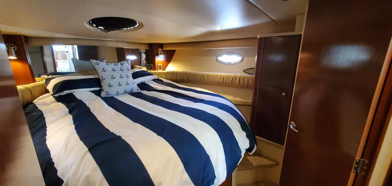 Chelarious Yacht Photos Pics Luxurious bedroom interior of 2005 Meridian 411 Sedan yacht with striped bedding.