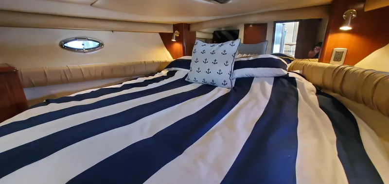 Chelarious Yacht Photos Pics 2005 Meridian 411 Sedan interior with striped bedding and nautical-themed pillow.