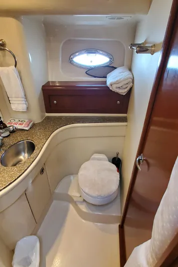 Chelarious Yacht Photos Pics Luxurious bathroom in 2005 Meridian 411 Sedan yacht with sink, toilet, and porthole window.