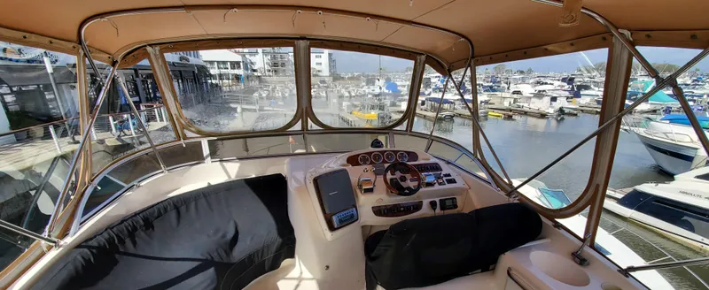 Chelarious Yacht Photos Pics 2005 Meridian 411 Sedan yacht cockpit with marina view, featuring navigation controls and seating.