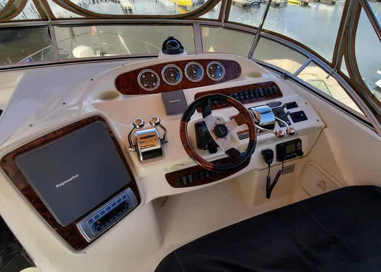 Chelarious Yacht Photos Pics Helm of 2005 Meridian 411 Sedan yacht with steering wheel and navigation controls.