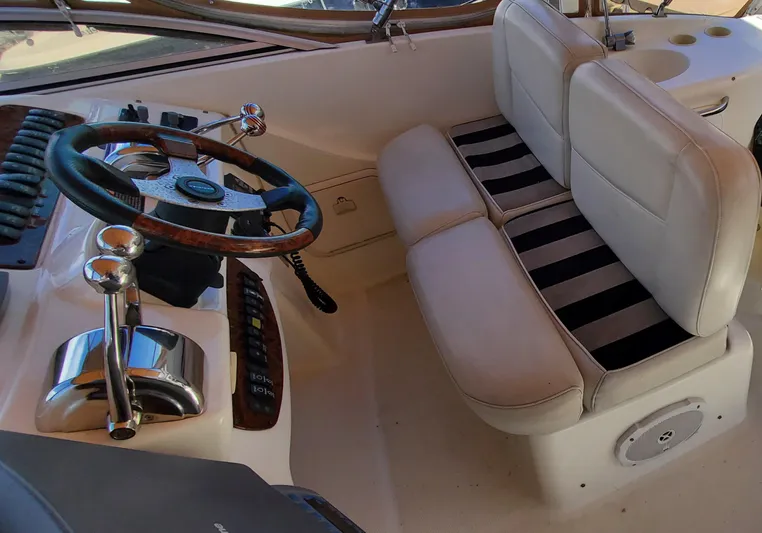 Chelarious Yacht Photos Pics 2005 Meridian 411 Sedan helm with leather seats and wooden steering wheel.