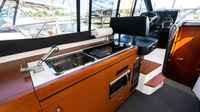  Yacht Photos Pics Interior of 2018 Jeanneau NC11 boat with kitchen and helm station.