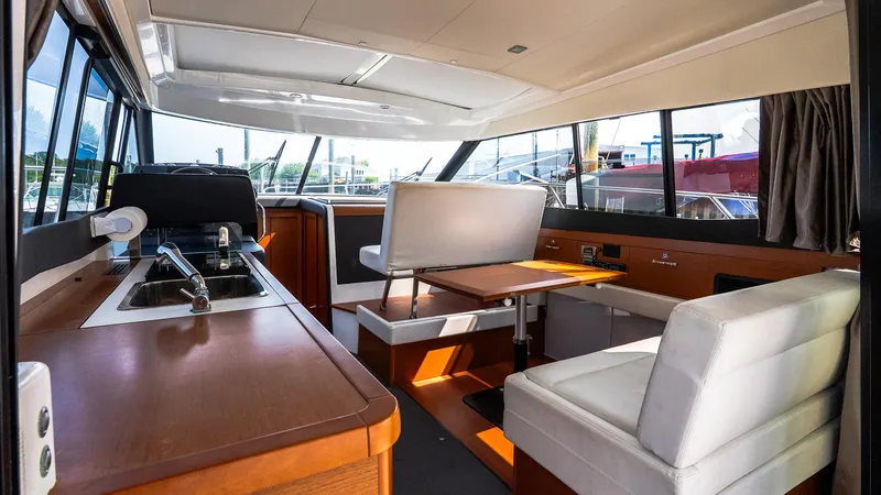  Yacht Photos Pics Interior of 2018 Jeanneau NC11 yacht with modern seating and kitchen area.