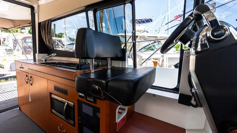  Yacht Photos Pics Interior of 2018 Jeanneau NC11 boat with helm and kitchenette area.