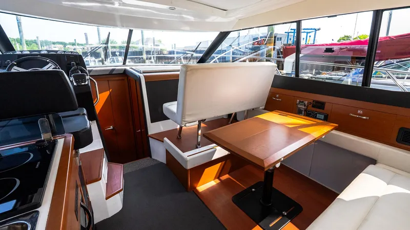  Yacht Photos Pics 2018 Jeanneau NC11 interior with modern seating, table, and helm station.