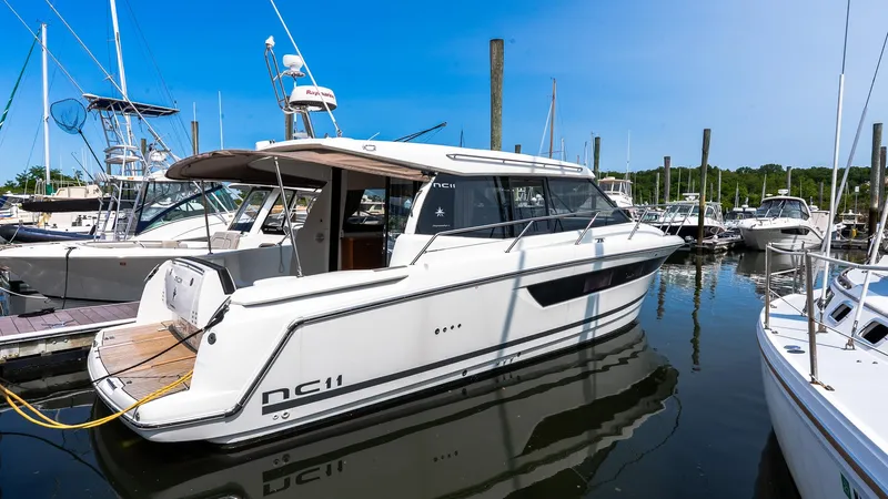  Yacht Photos Pics 2018 Jeanneau NC11 yacht docked in a marina under clear blue skies.