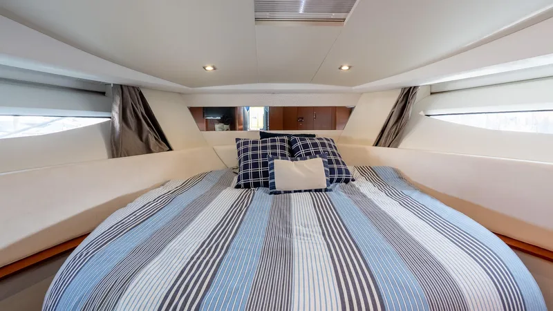  Yacht Photos Pics 2018 Jeanneau NC11 cabin with striped bedding and modern interior design.