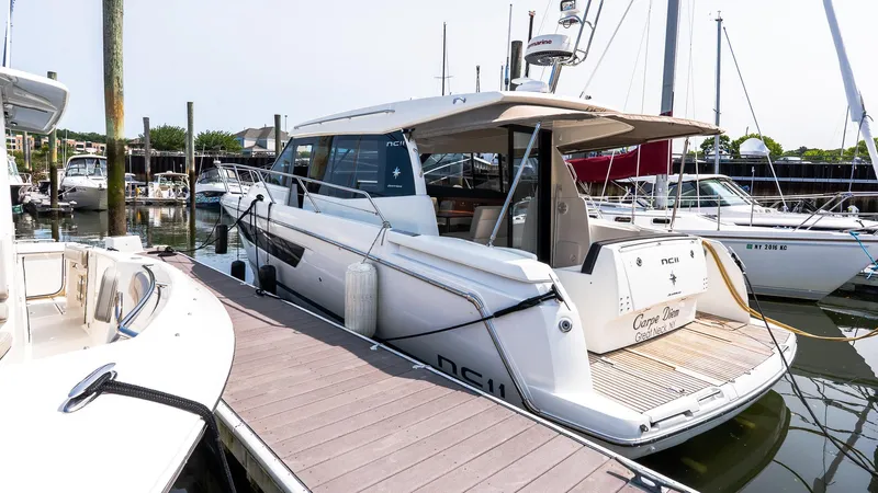  Yacht Photos Pics 2018 Jeanneau NC11 yacht docked at marina, showcasing sleek design and modern features.