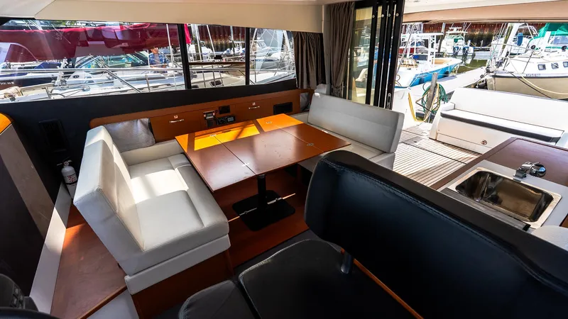  Yacht Photos Pics Interior of 2018 Jeanneau NC11 yacht with seating, table, and kitchenette.