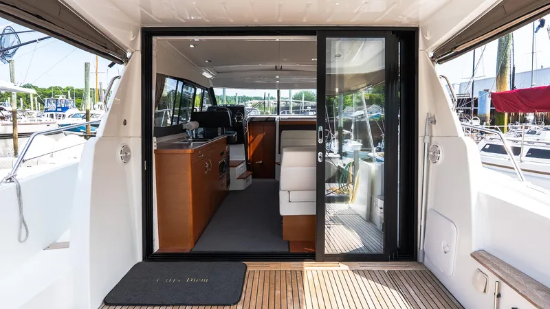  Yacht Photos Pics 2018 Jeanneau NC11 yacht interior with sliding glass doors and wooden flooring.