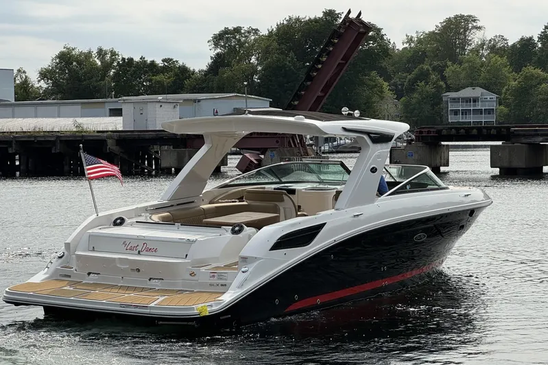  Yacht Photos Pics 2024 Sea Ray SLX 350 luxury boat on water, American flag, bridge in background.
