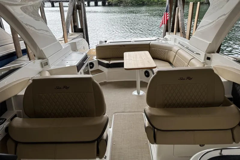  Yacht Photos Pics 2024 Sea Ray SLX 350 boat interior with luxurious seating and table, docked by the water.