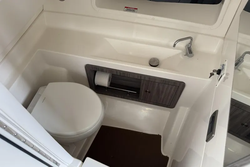  Yacht Photos Pics 2024 Sea Ray SLX 350 boat bathroom with toilet, sink, and storage cabinet.