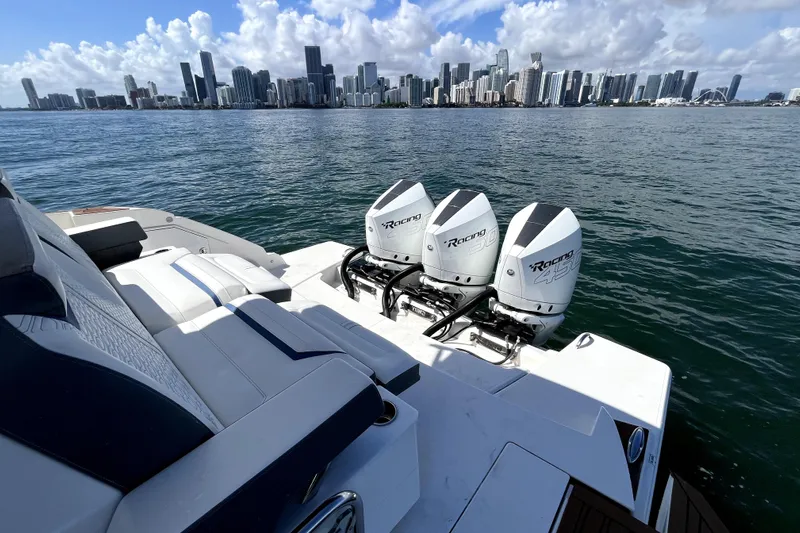  Yacht Photos Pics 2021 Tiara Yachts 43 LE with triple outboard engines, city skyline in background.