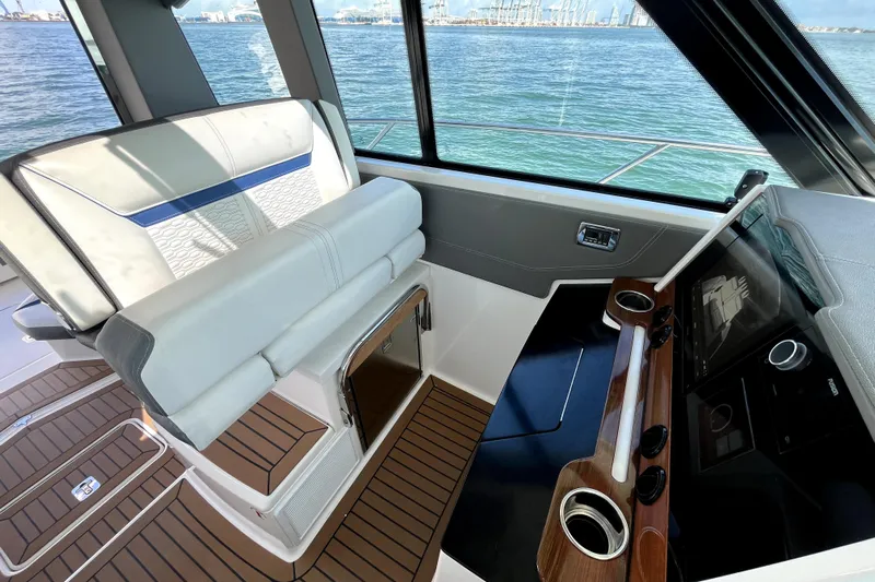  Yacht Photos Pics 2021 Tiara Yachts 43 LE helm with luxurious seating and modern controls, overlooking the ocean.