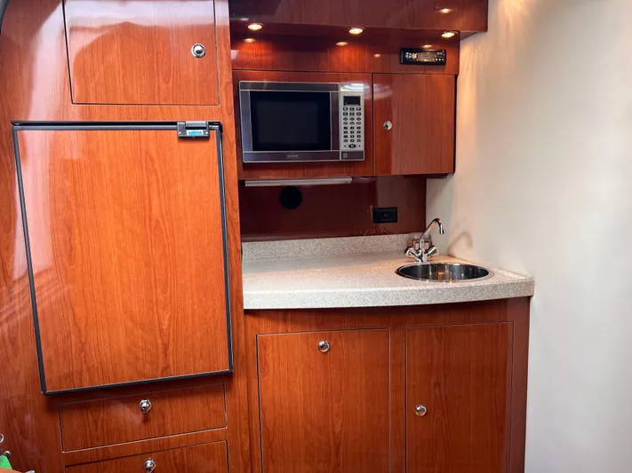 Sharon Ann Yacht Photos Pics 2007 Regal Commodore 3760 IB yacht kitchen with wood cabinetry, microwave, and sink.