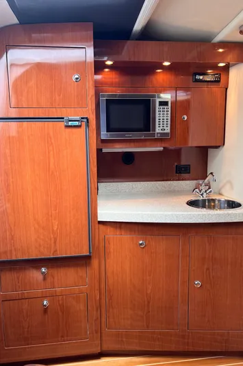 Sharon Ann Yacht Photos Pics 2007 Regal Commodore 3760 IB yacht kitchen with wood cabinetry, microwave, and sink.