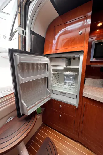 Sharon Ann Yacht Photos Pics 2007 Regal Commodore 3760 IB yacht interior with open fridge and wooden cabinetry.