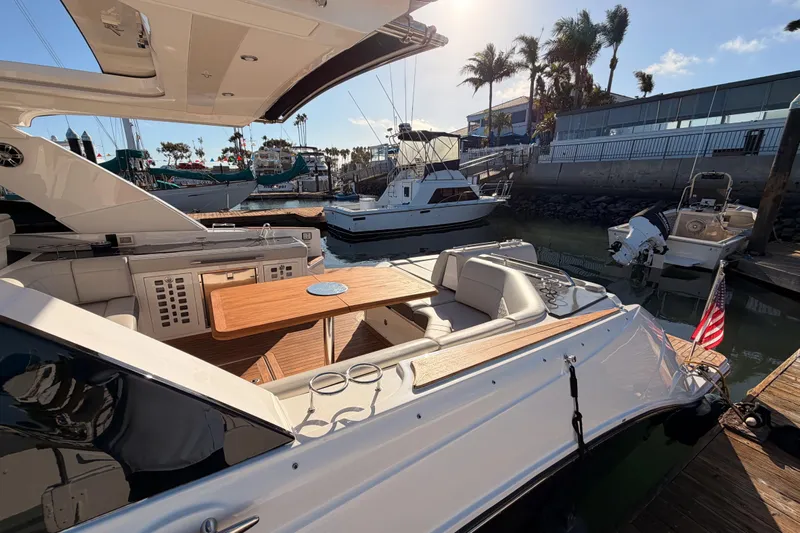  Yacht Photos Pics 2021 Sea Ray SLX 400 yacht docked, featuring a spacious seating area and wooden table.