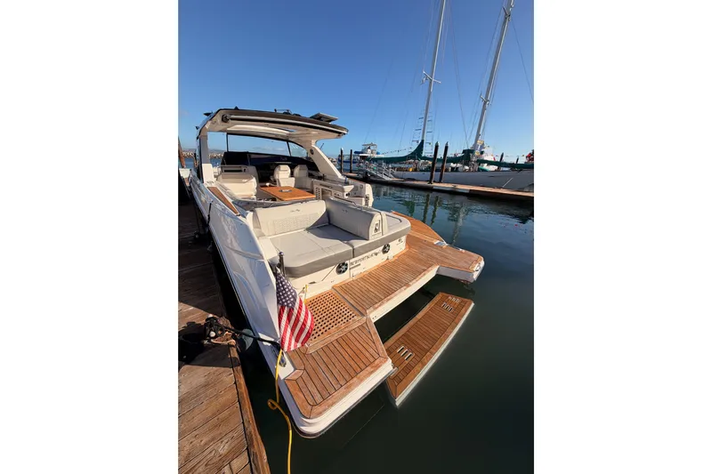  Yacht Photos Pics 2021 Sea Ray SLX 400 yacht docked, featuring spacious deck and American flag.