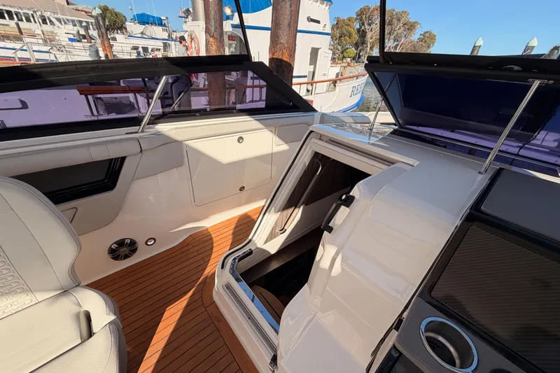  Yacht Photos Pics 2021 Sea Ray SLX 400 interior with open cabin door, showcasing luxury seating and wood flooring.