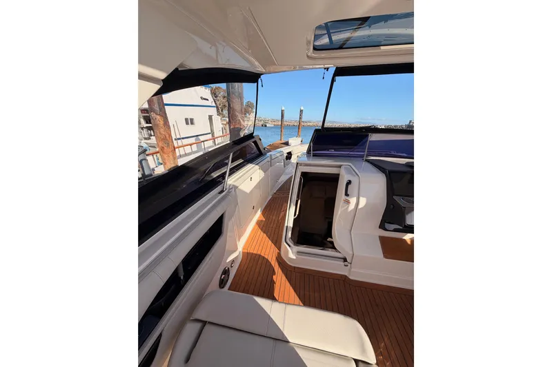  Yacht Photos Pics 2021 Sea Ray SLX 400 boat interior with open cabin door and wooden deck.