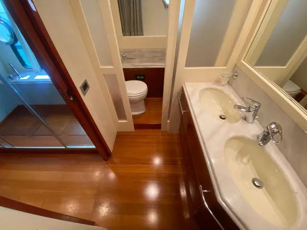 Lidia Yacht Photos Pics Luxurious bathroom in 2006 Ferretti Yachts 830, featuring dual sinks and wooden flooring.