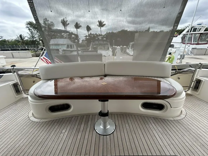 Uniq III Yacht Photos Pics Luxury seating area on 2008 Princess 67 Flybridge yacht with wooden table.