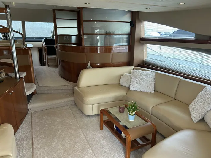 Uniq III Yacht Photos Pics Luxurious interior of 2008 Princess 67 Flybridge yacht with beige seating and wooden accents.