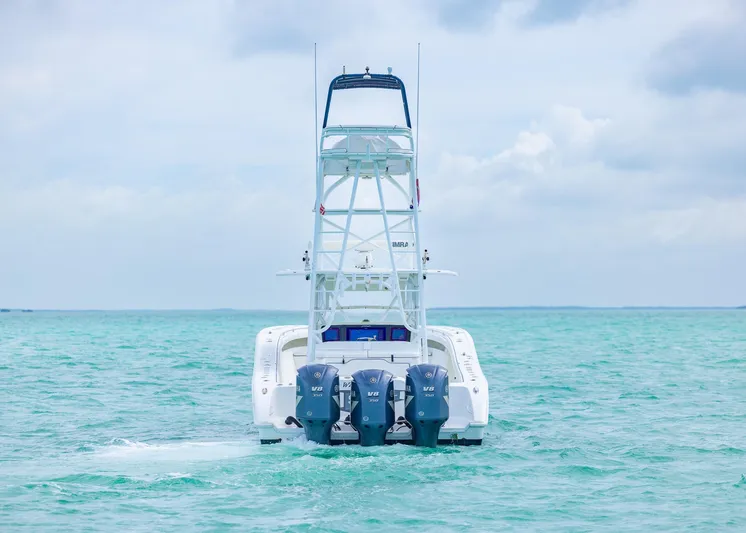 Yacht Photos Pics 2011 Yellowfin 42 Offshore boat with triple engines on turquoise water.