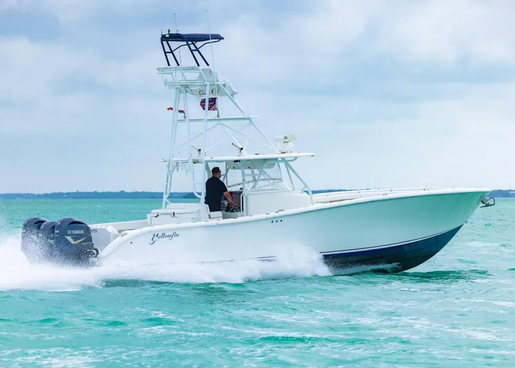  Yacht Photos Pics 2011 Yellowfin 42 Offshore boat cruising on turquoise water under cloudy sky.