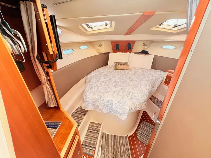 Reliance Yacht Photos Pics Interior of 2023 Cutwater 32 Coupe featuring cozy bed and wood accents.