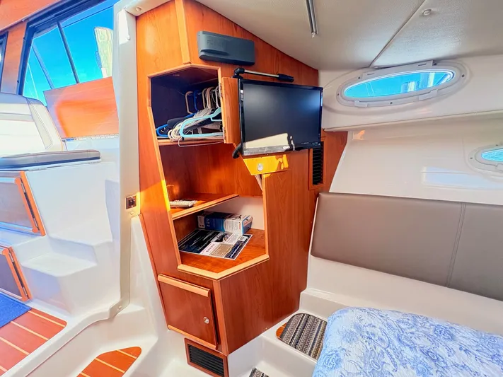 Reliance Yacht Photos Pics Interior of 2023 Cutwater 32 Coupe with wooden cabinets and TV.