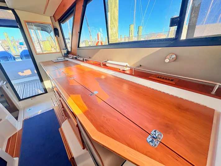 Reliance Yacht Photos Pics Interior of 2023 Cutwater 32 Coupe with wooden table and windows.