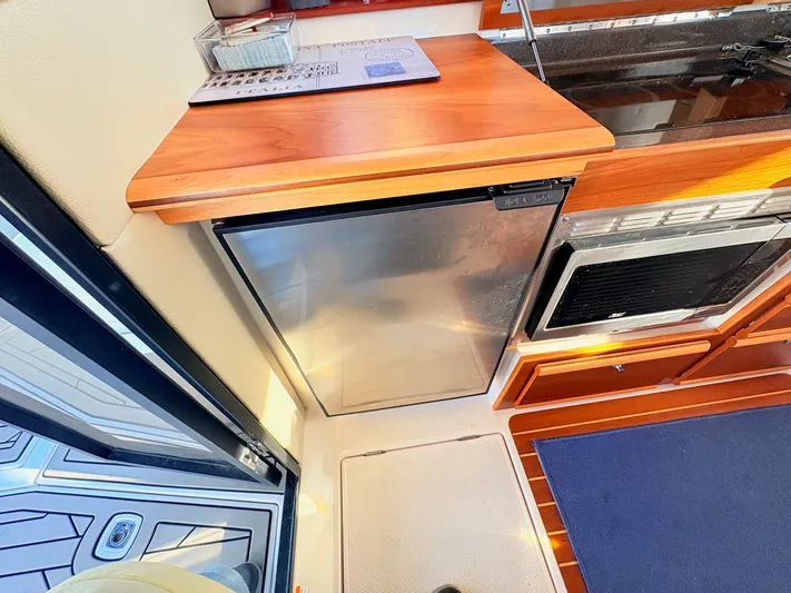 Reliance Yacht Photos Pics Interior of 2023 Cutwater 32 Coupe with fridge and wooden countertop.