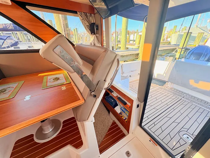 Reliance Yacht Photos Pics Interior of 2023 Cutwater 32 Coupe with wooden table and seating area.