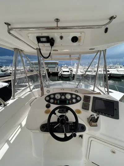  Yacht Photos Pics 2005 Riviera 37 Flybridge helm with marina view, featuring modern navigation equipment.