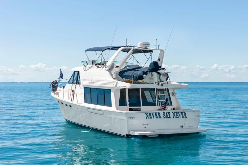 Never Say Never Yacht Photos Pics 1997 Bayliner 4788 Pilot House Motoryacht on calm blue waters, rear view.