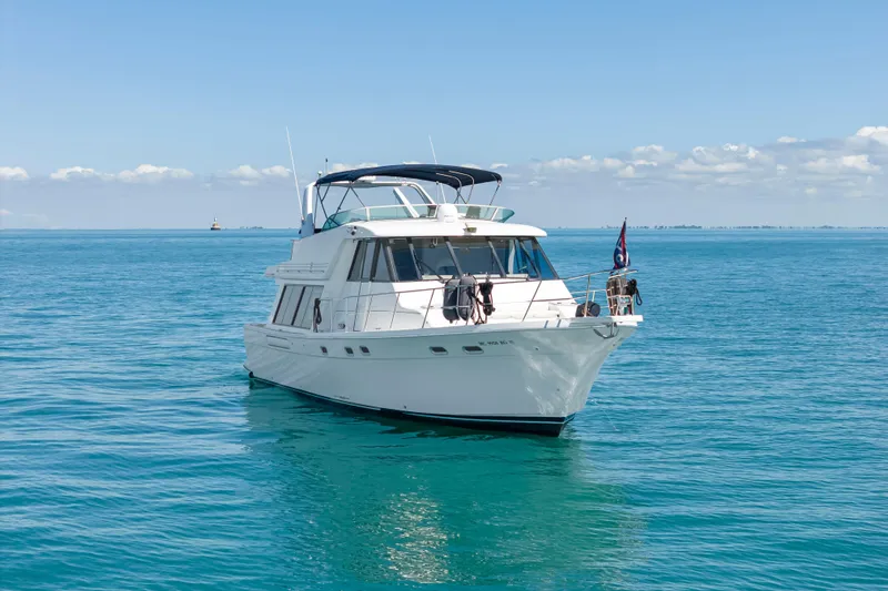 Never Say Never Yacht Photos Pics 1997 Bayliner 4788 Pilot House Motoryacht cruising on clear blue waters.