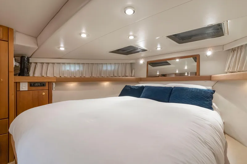Never Say Never Yacht Photos Pics Luxurious bedroom interior of 1997 Bayliner 4788 Pilot House Motoryacht with cozy bedding.