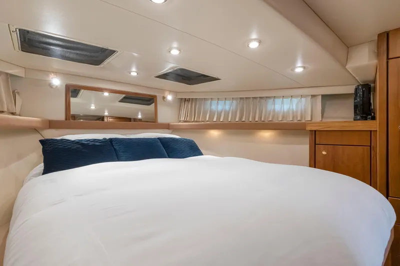 Never Say Never Yacht Photos Pics Luxurious bedroom interior of 1997 Bayliner 4788 Pilot House Motoryacht with cozy bedding.