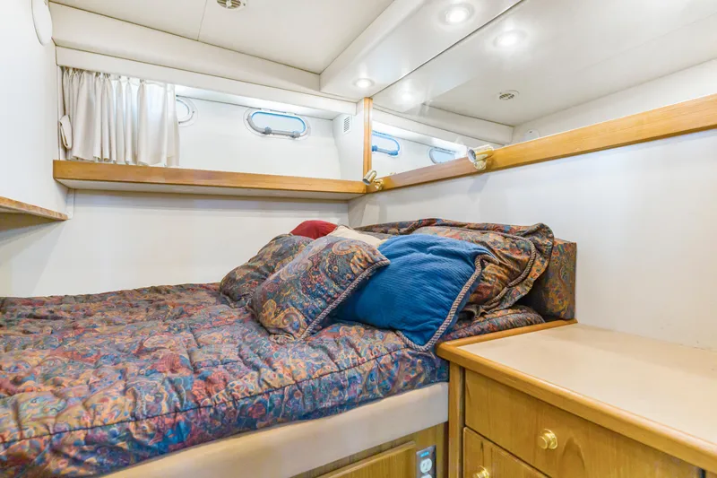 Never Say Never Yacht Photos Pics Cozy bedroom in 1997 Bayliner 4788 Pilot House Motoryacht with colorful bedding and wood accents.