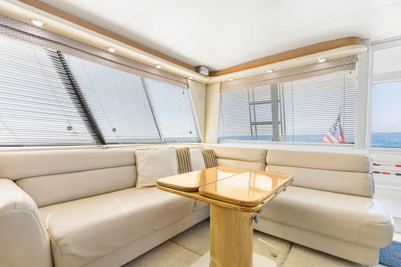 Never Say Never Yacht Photos Pics Luxurious interior of 1997 Bayliner 4788 Pilot House Motoryacht with plush seating and wooden table.