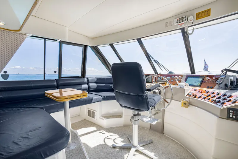Never Say Never Yacht Photos Pics Interior of 1997 Bayliner 4788 Pilot House Motoryacht with helm and seating area.