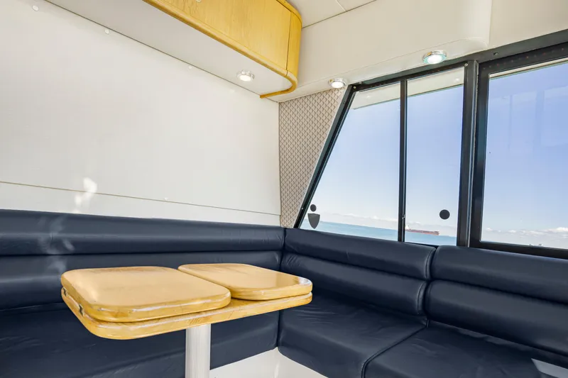Never Say Never Yacht Photos Pics Interior of 1997 Bayliner 4788 Pilot House Motoryacht with blue seating and ocean view.