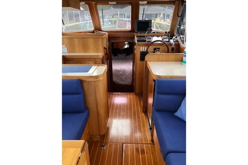 Ocean Baron Yacht Photos Pics Interior of a 2001 Sabreline Sedan boat with wooden flooring and blue seating.