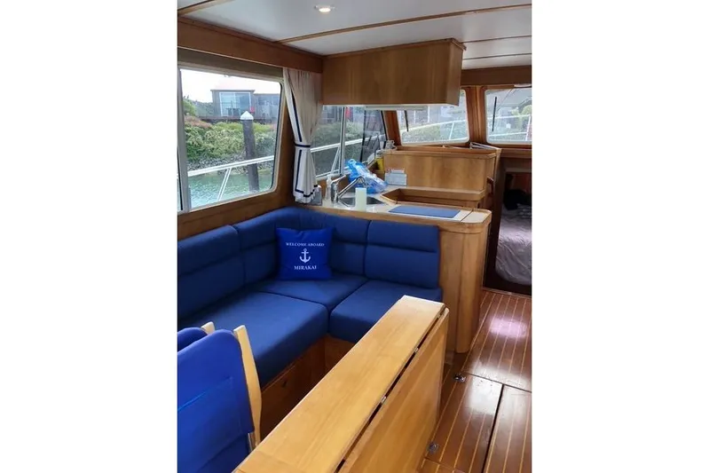 Ocean Baron Yacht Photos Pics Interior of 2001 Sabreline Sedan boat with blue seating and wooden finishes.