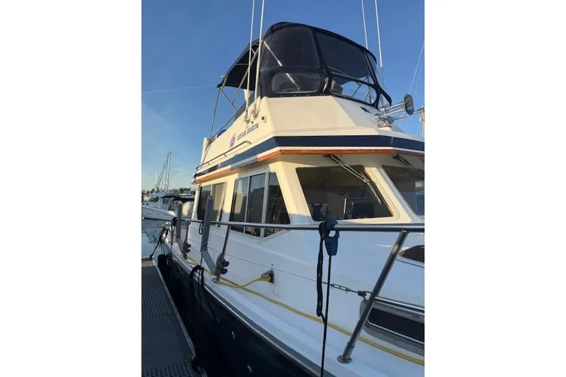 Ocean Baron Yacht Photos Pics 2001 Sabreline Sedan boat docked, featuring a sleek design and spacious upper deck.